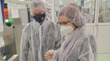 Two employees in protective caps and masks working in production