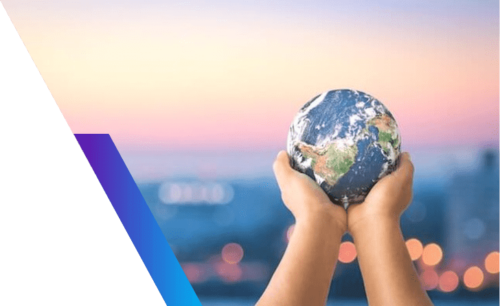 Hands holding a small globe of the Earth at sunset