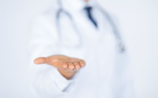 Healthcare worker in a white coat with an open hand