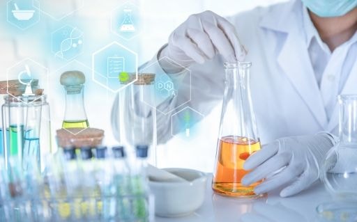 Chemist in a white coat pouring a solution in a laboratory