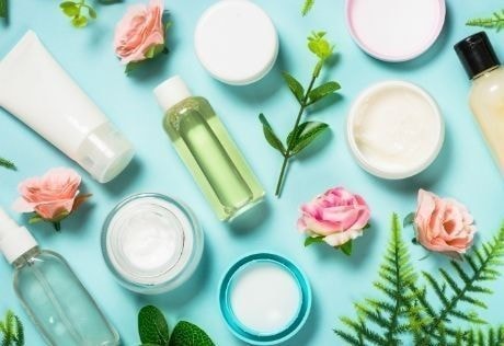 Cosmetic bottles and jars arranged with flowers and leaves