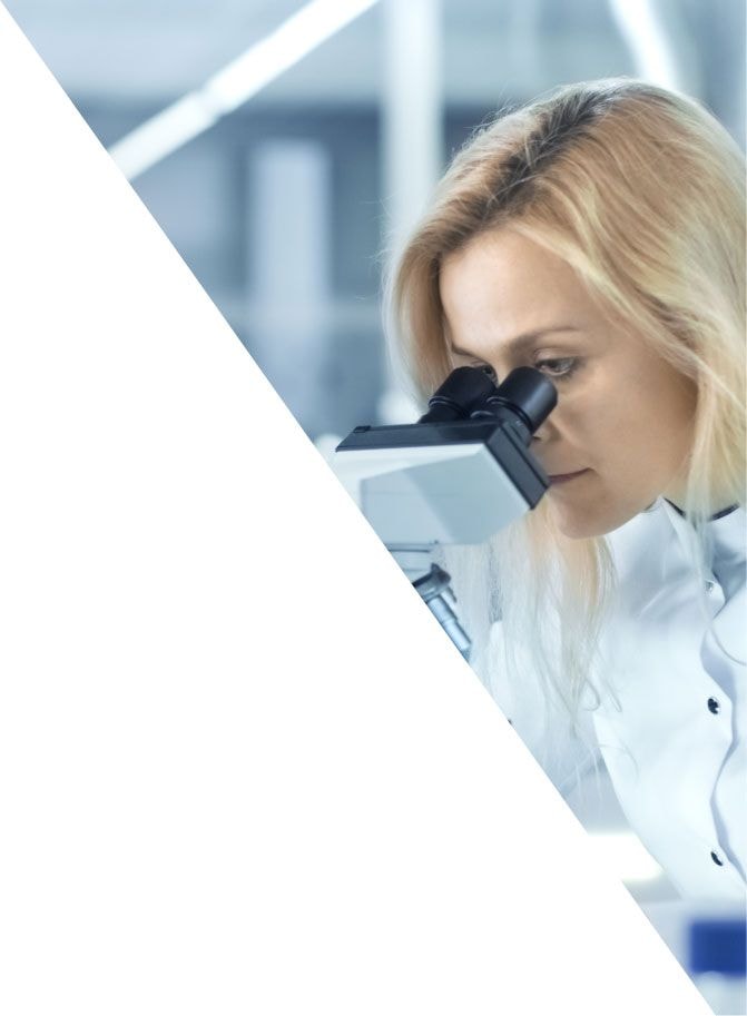 Researcher looking into a microscope in an Alkaloid laboratory
